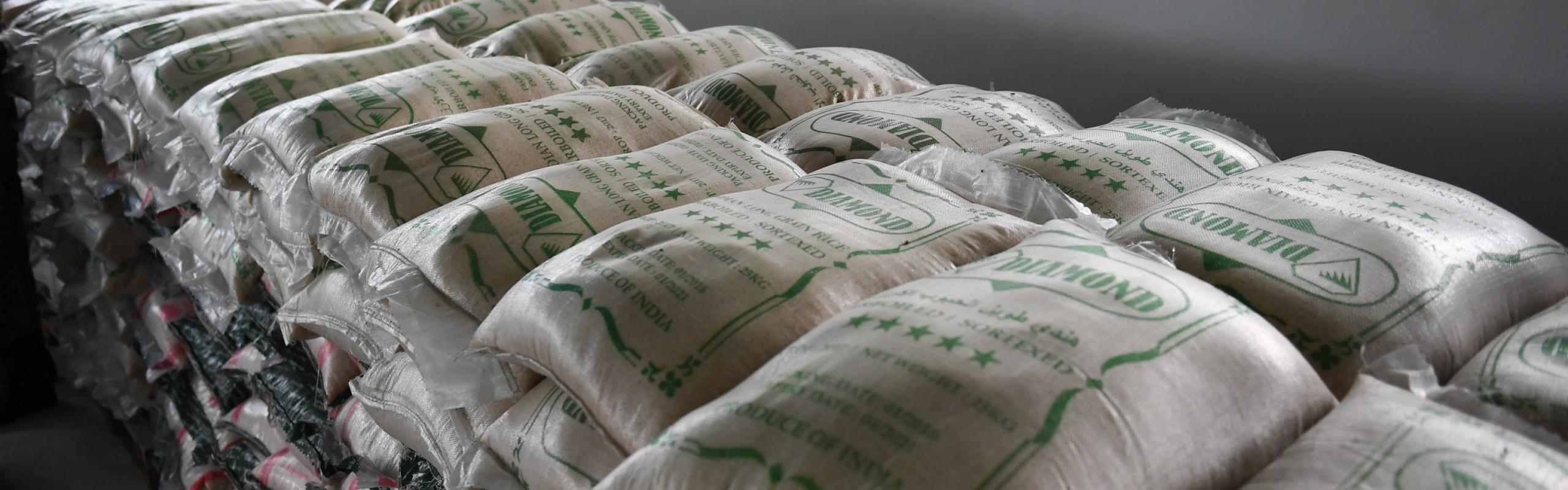Bags of rice, wheat flour, and sugar stacked in warehouse in Uganda.