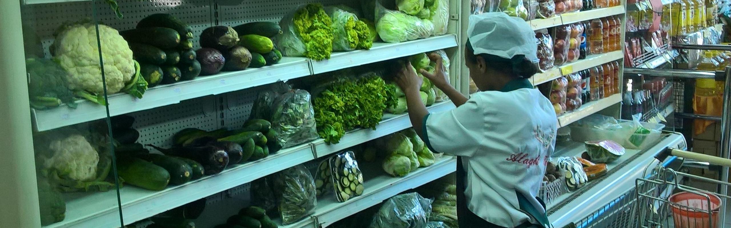 Un travailleur organise des légumes sur une étagère dans un supermarché à Addis-Abeba, en Éthiopie