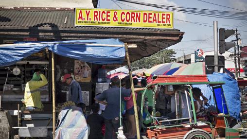 Rice and corn dealer outside Burgos street market Bacolod City, Philippines