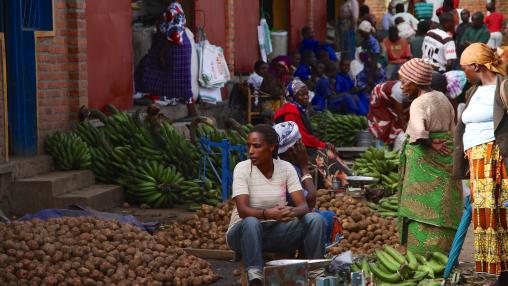 Vendors sitting among piles of potatoes and bananas in a marketplace, Musanze, Rwanda.