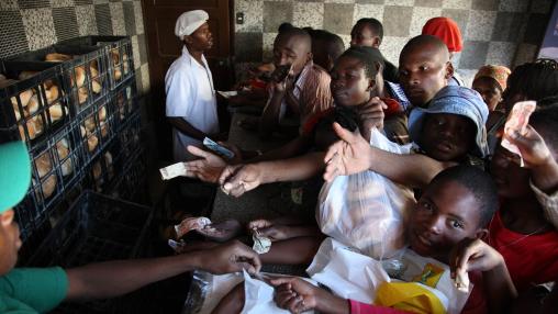 A crowd of people rush to buy bread, a staple food, after it arrives at a bakery in Mozambique. Supply disruptions and rising prices of wheat and other items are causing problems for countries in Africa and elsewhere as the Russia-Ukraine war continues.